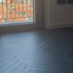 Soggiorno con parquet scuro a spina italiana e finitura in microresina, progetto Braga Pavimenti