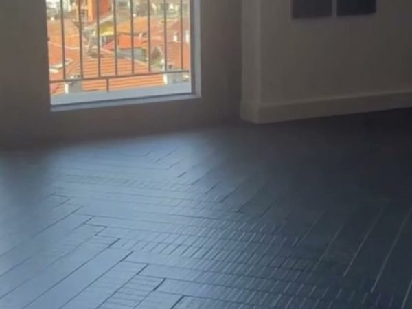 Soggiorno con parquet scuro a spina italiana e finitura in microresina, progetto Braga Pavimenti