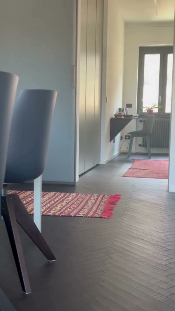 Parquet a spina italiana scuro con finitura in microresina nella zona pranzo e nel corridoio